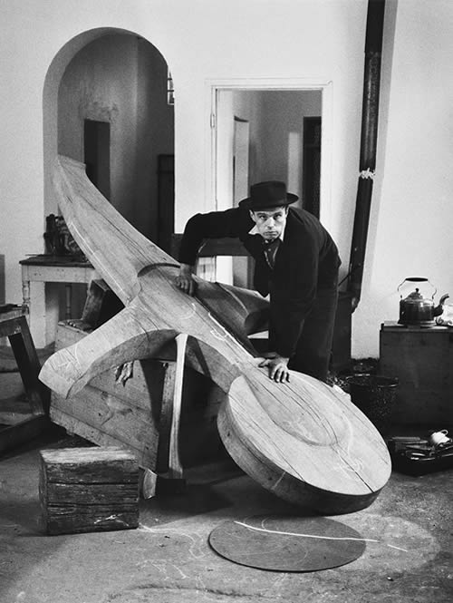 Joseph Beuys in his studio in the Kleve spa house, bent over the cross for the “Büderich Monument”, 1959